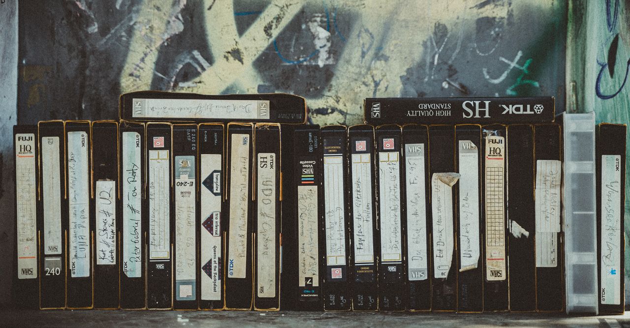 Een rij oude VHS-videobanden met handgeschreven etiketten